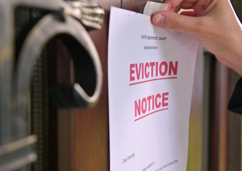 pinning an eviction notice to a wooden front door