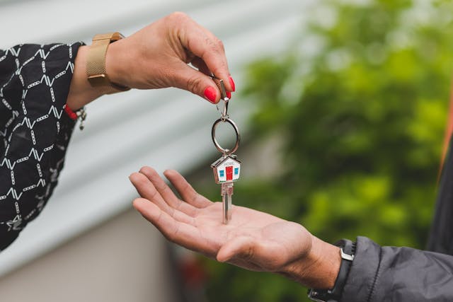 A hand handing a key